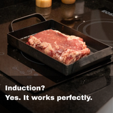 La Planchettita van warmgewalst ijzer met een steak op een inductiekookplaat